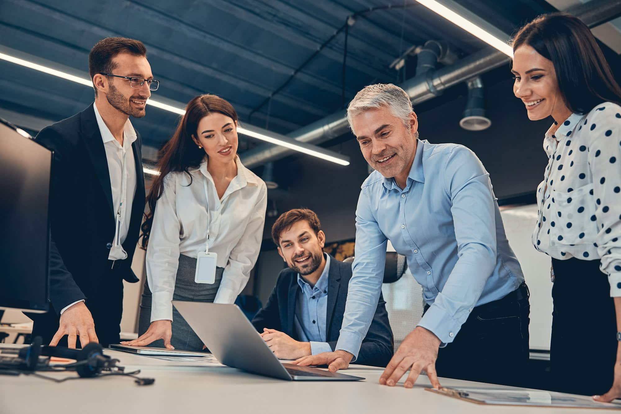Group of young modern people in formal wear communicating and using modern technologie